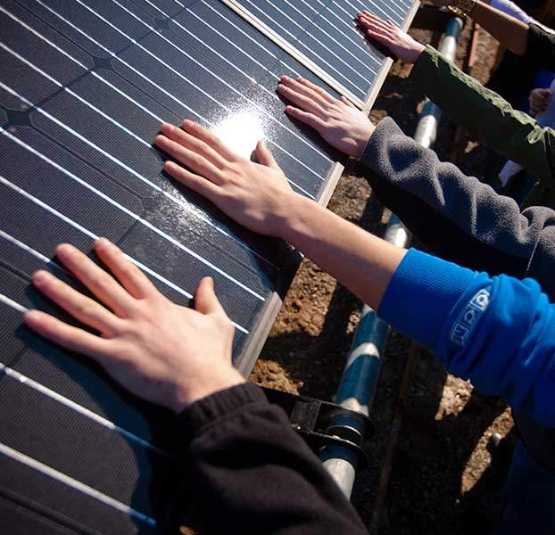 Hands touching solar panel