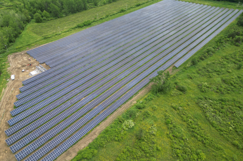 Aerial view of approx. 20 rows of solar panels in a field